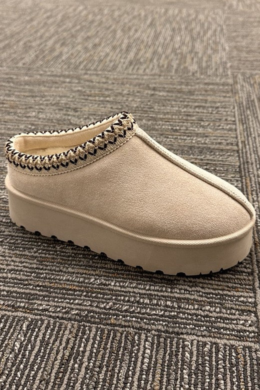 Side view of the cream suede clogs