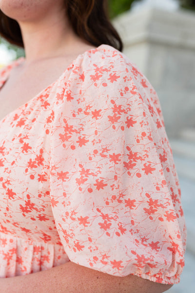 Close up of the sleeve and fabric on the plus size peach floral tiered dress