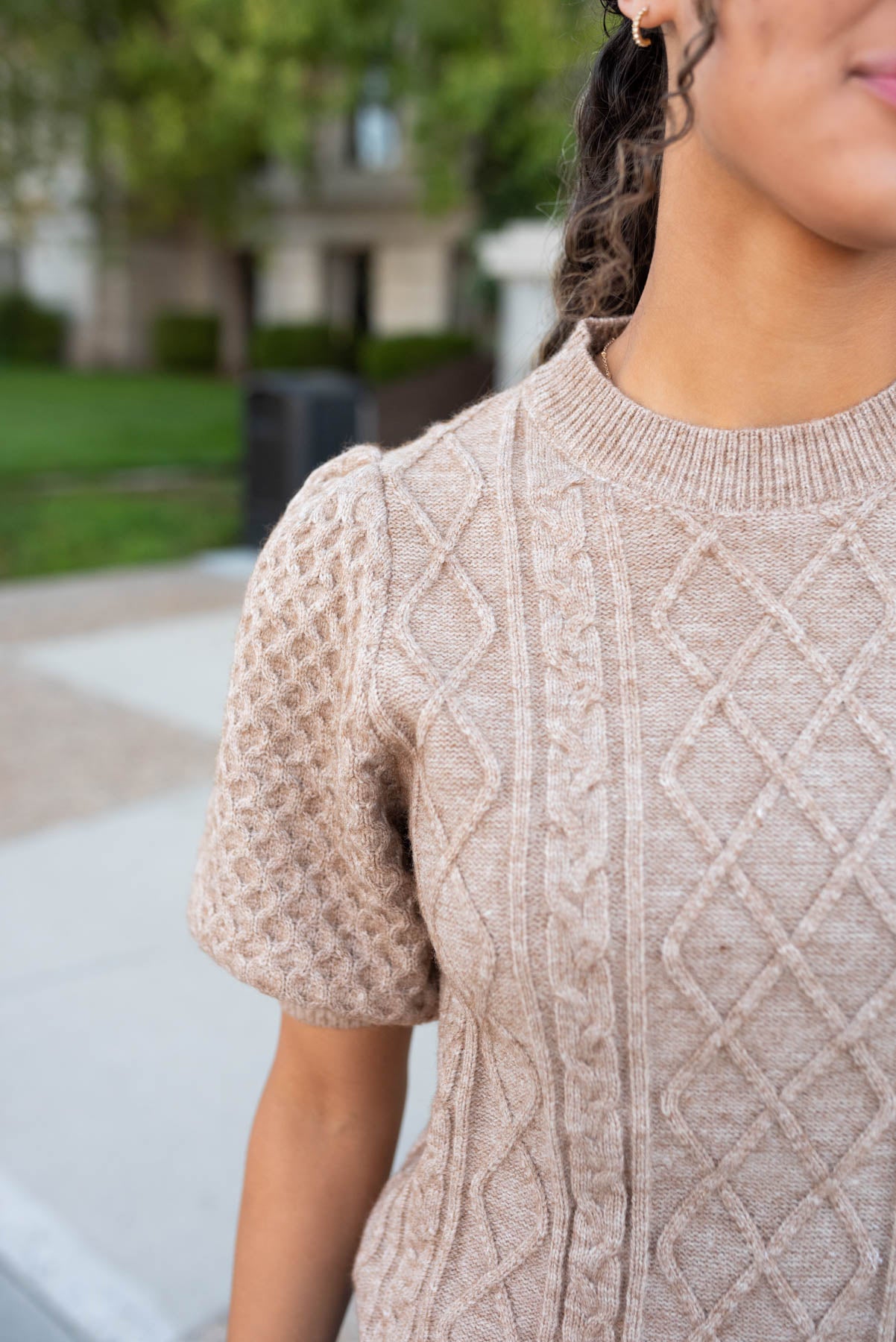 Close up of the sleeve on the taupe short sleeve sweater