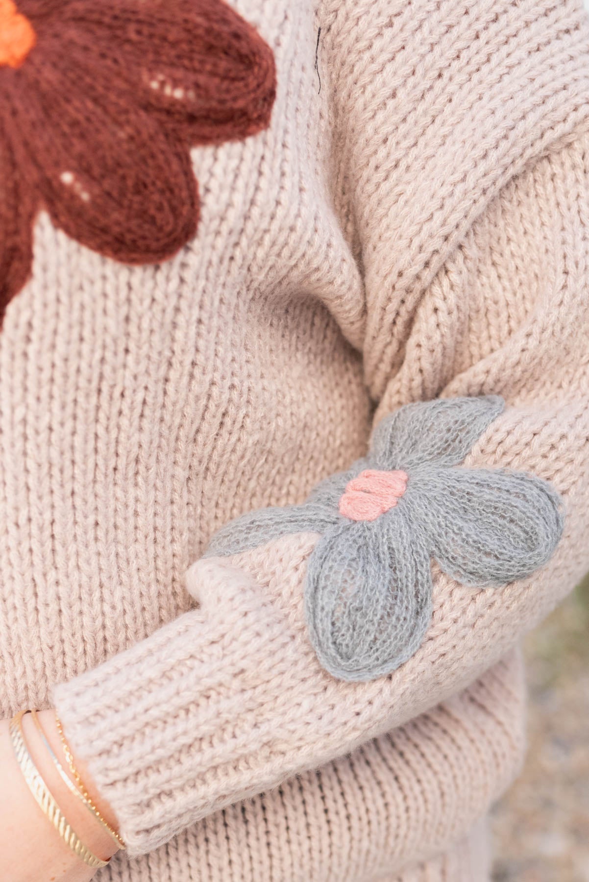 Close up of the sitched flowers on the plus size natural flower sweater