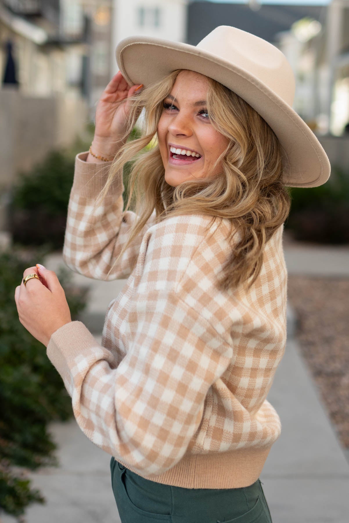 Side view of a taupe checkered button cardigan