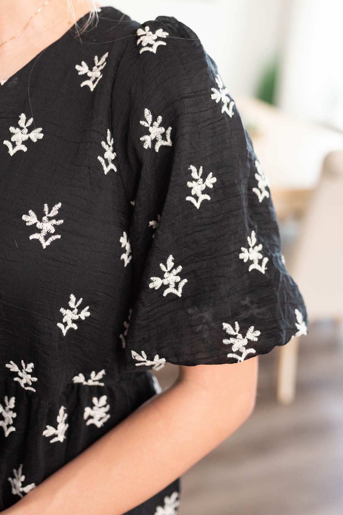 Close up of the fabric and sleeves on the black embroidered dress