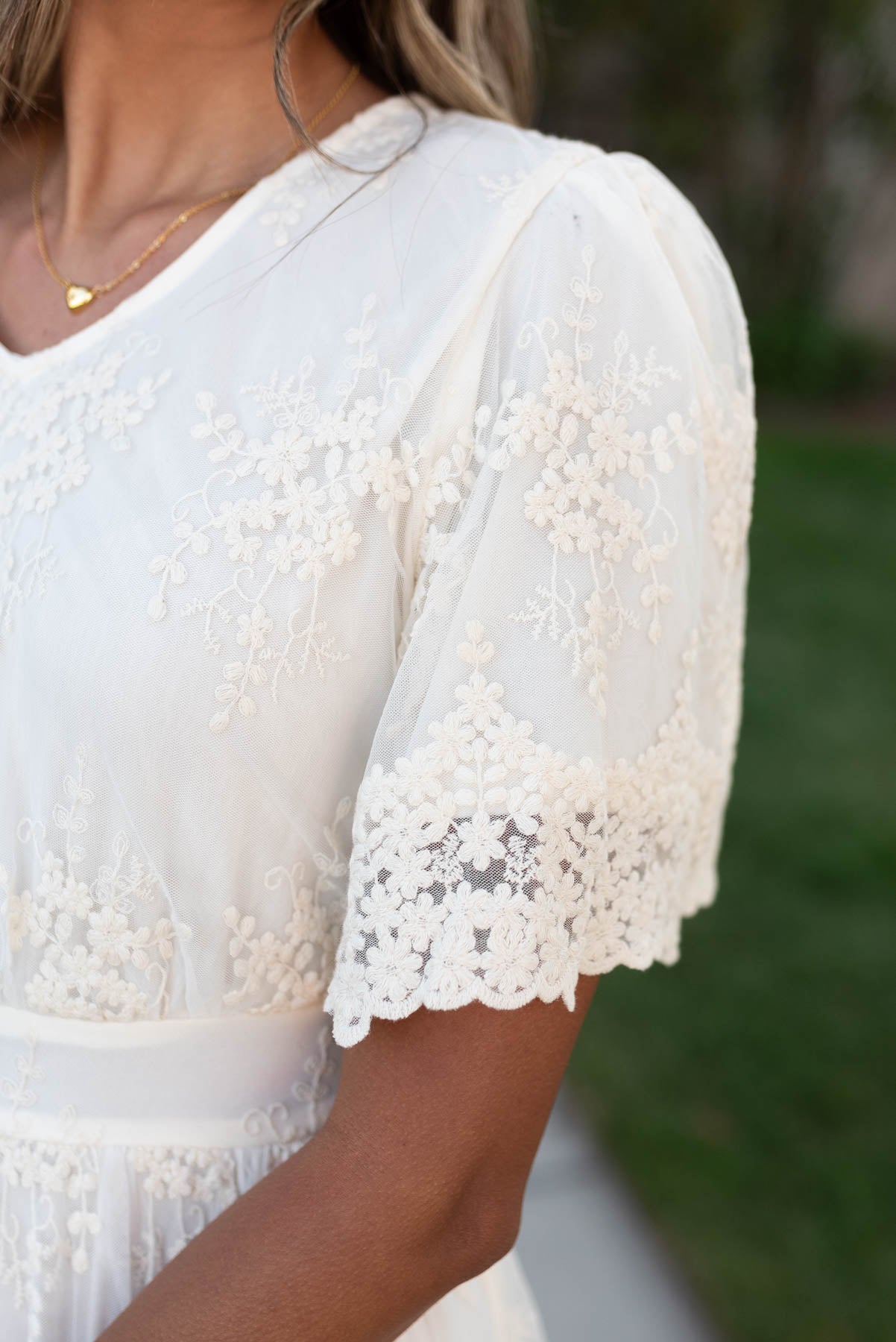 Close up of the sleeve on the cream lace embroidered dress