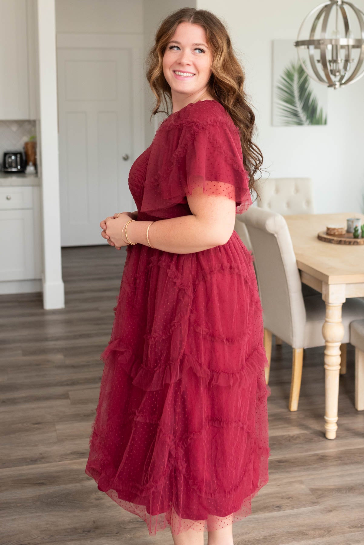 Side view of the plus size burgundy smocked ruffle dress