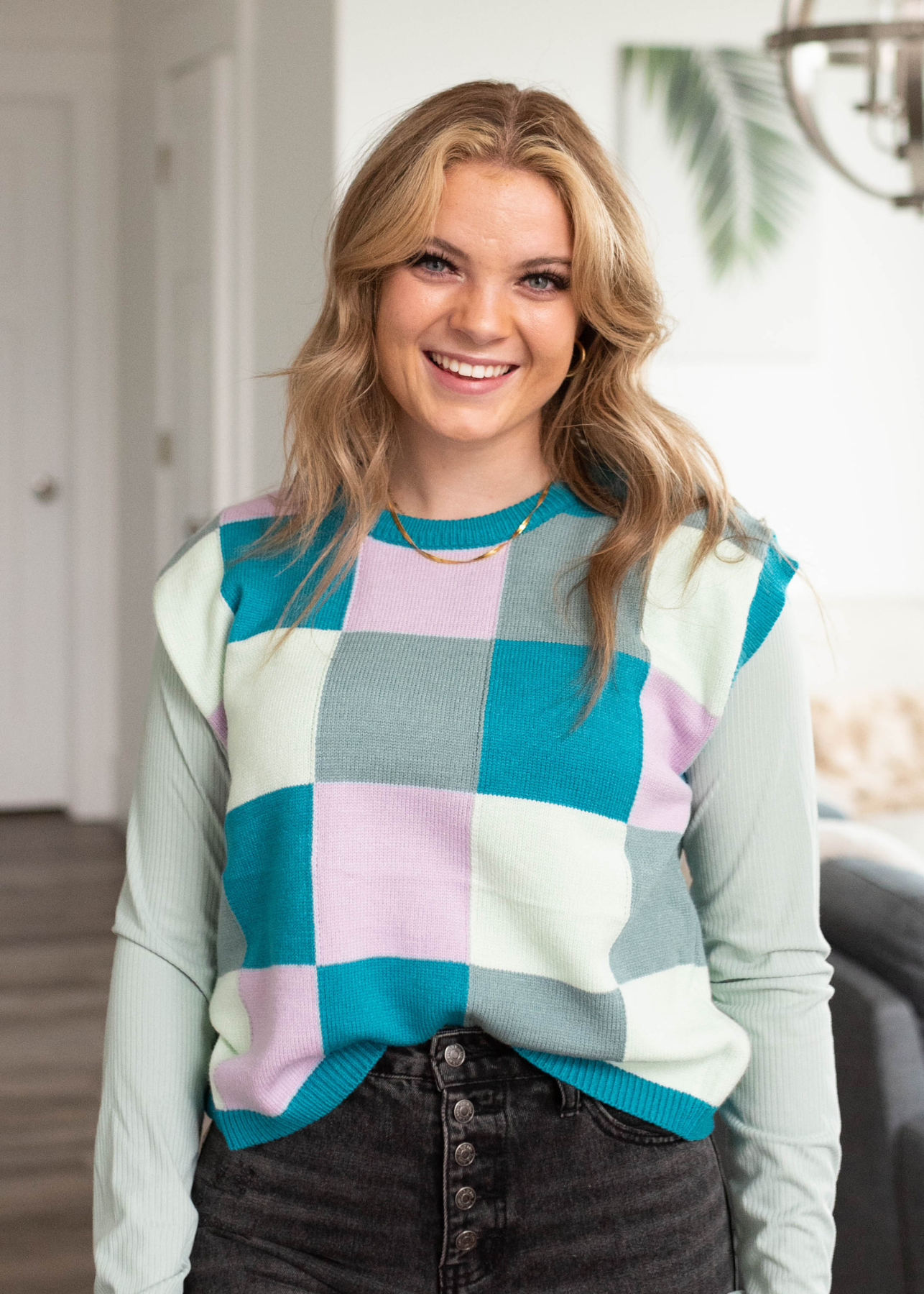 Close up view of the teal checkered sweater vest