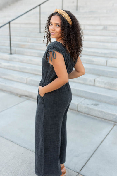 Side view of the black mineral wash jumpsuit with pockets