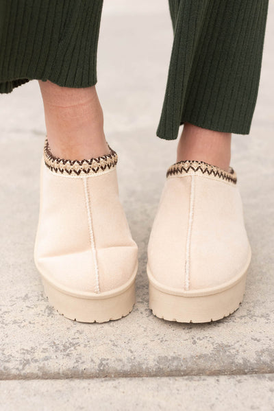 Font view of the beige suede clogs