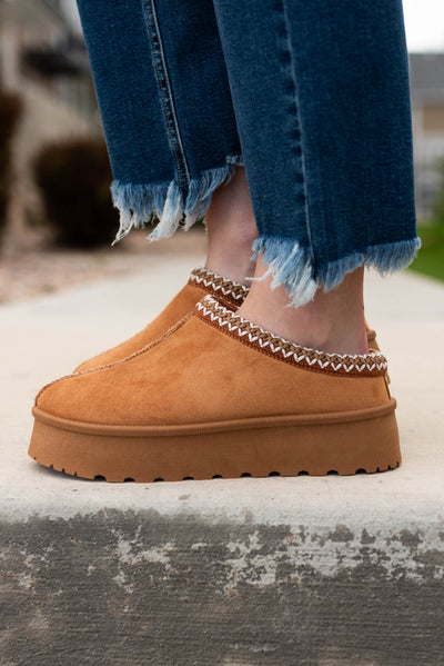 Side view of the tan suede clogs