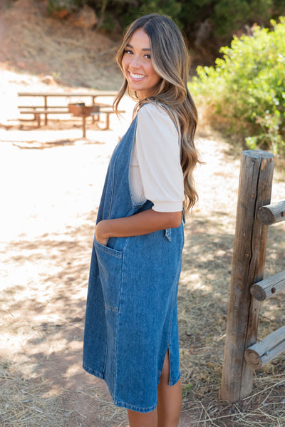 Side view of the indigo denim overall dress