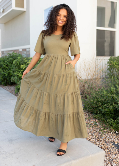 Front view of the olive flroal embroidered dress with pockets