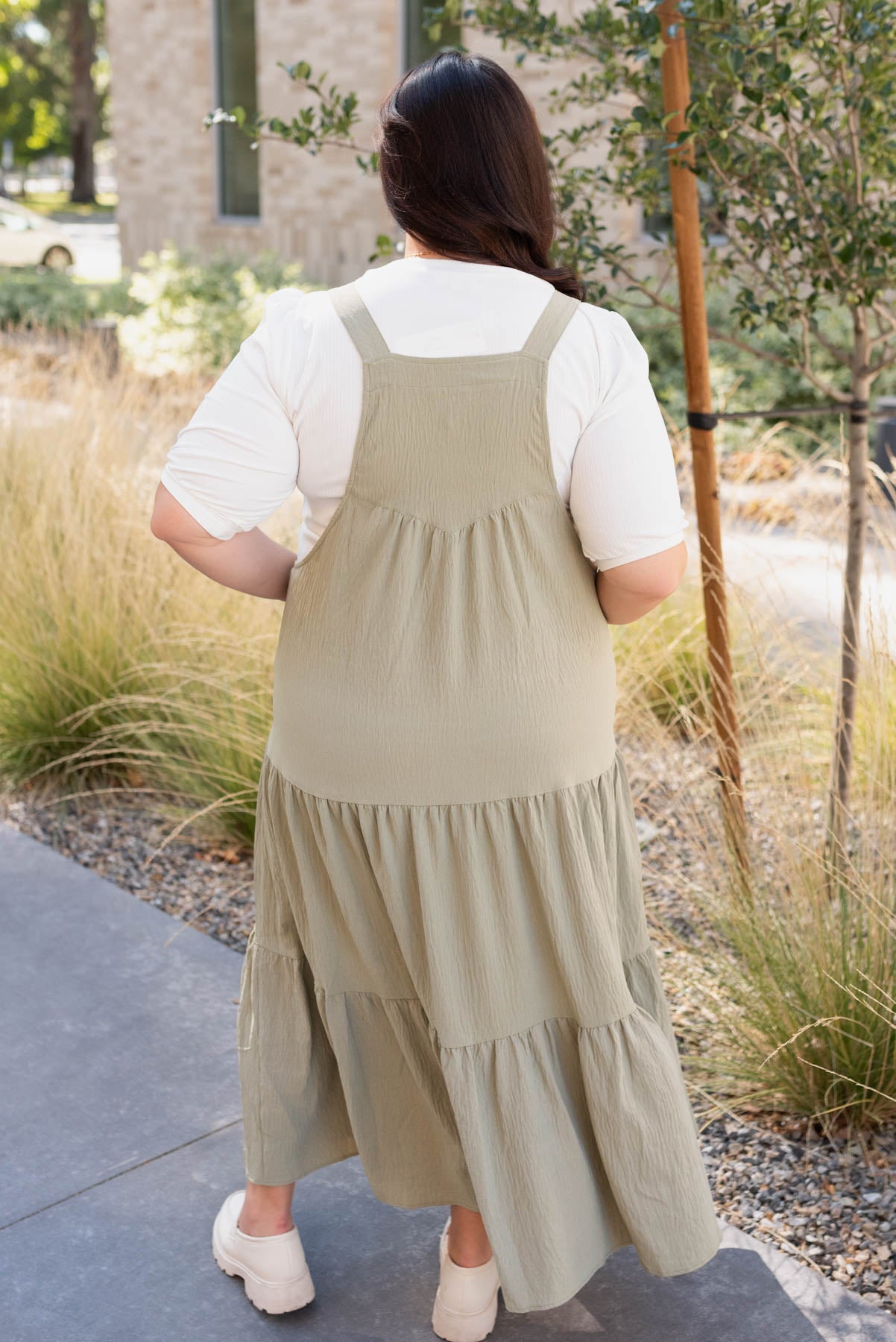 Plus size back view of the sage green overall dress