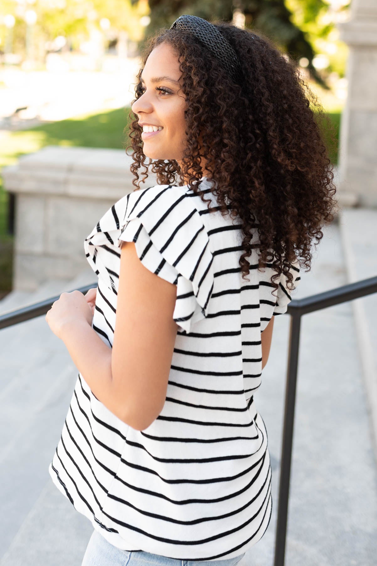 View of the ruffle sleeve on the black stripe ruffle top