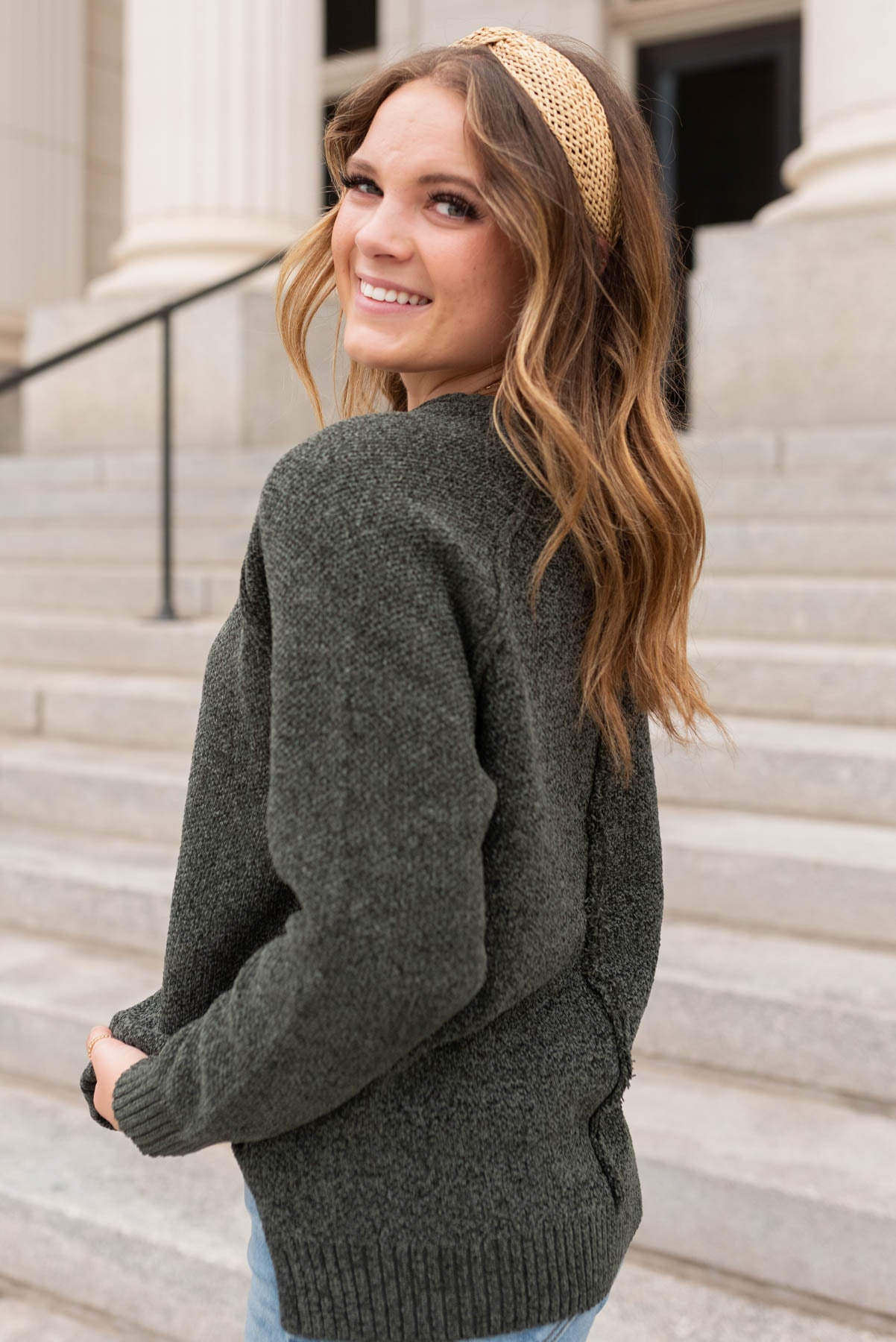 Side view of the dark olive knitted sweater