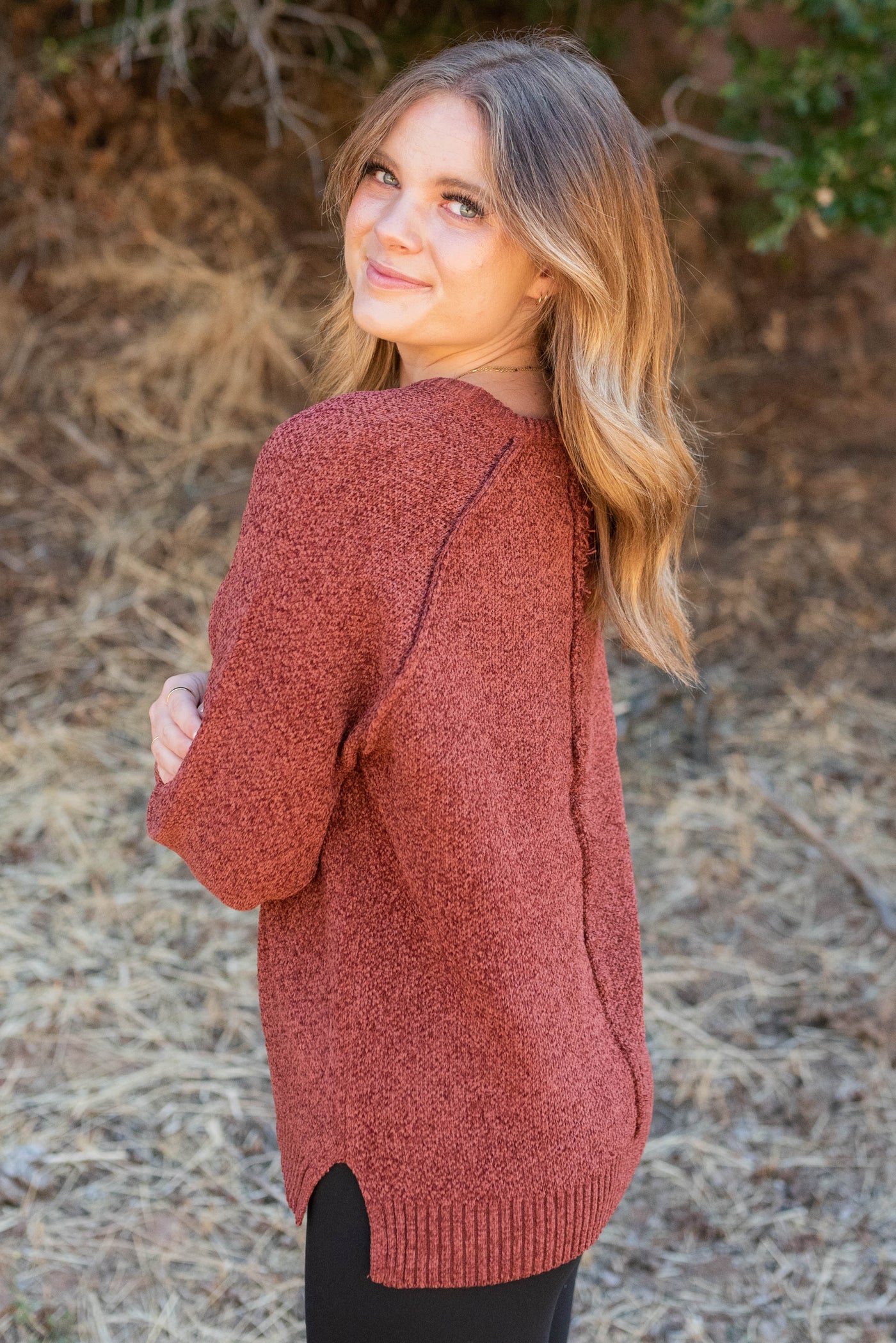 Side view of the dark rust knitted sweater