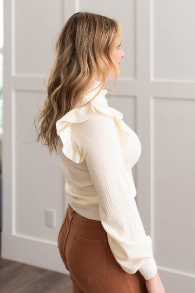 Side view of the ivory ruffle turtleneck sweater