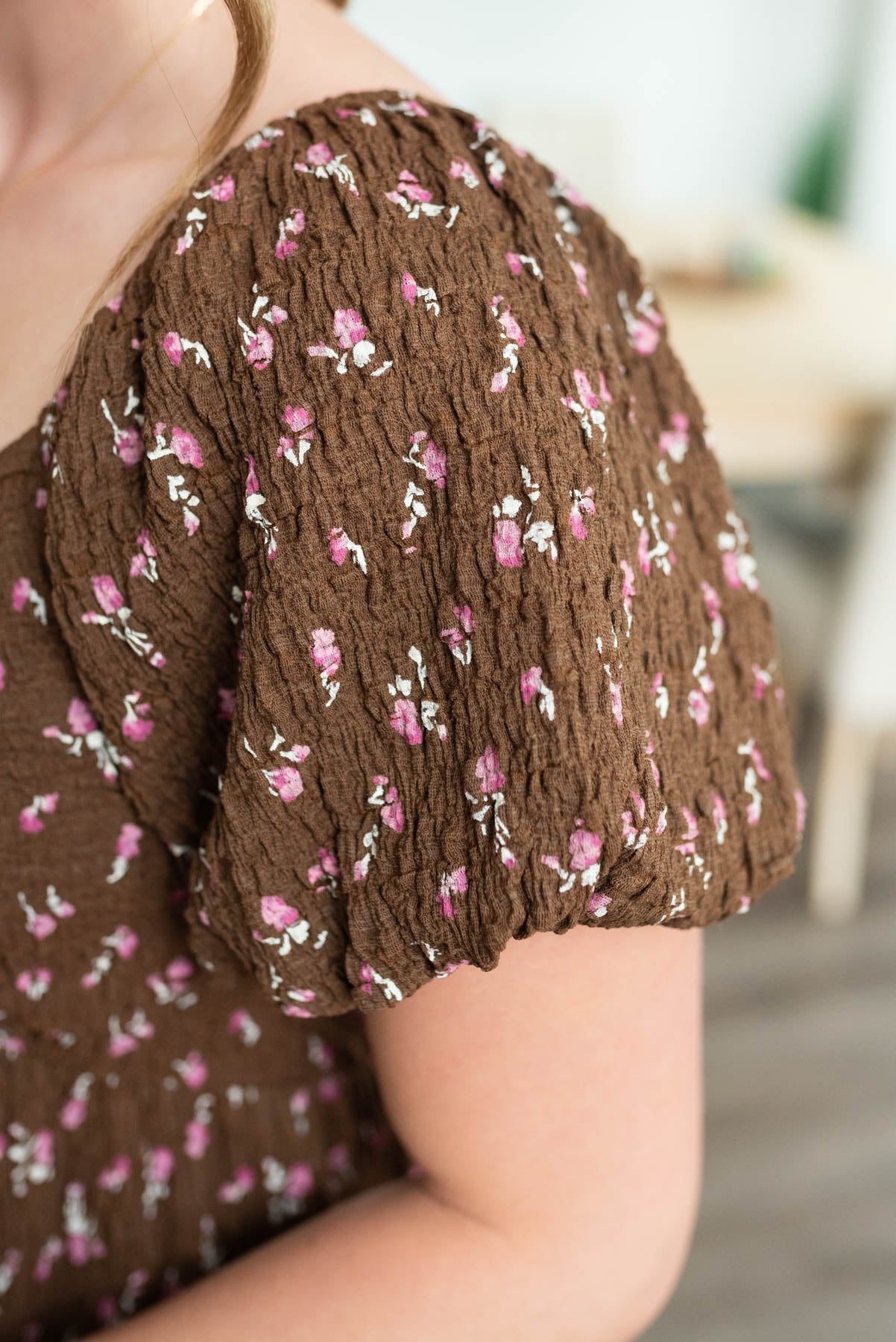 Close up of the sleeve and fabric on the brown floral dress