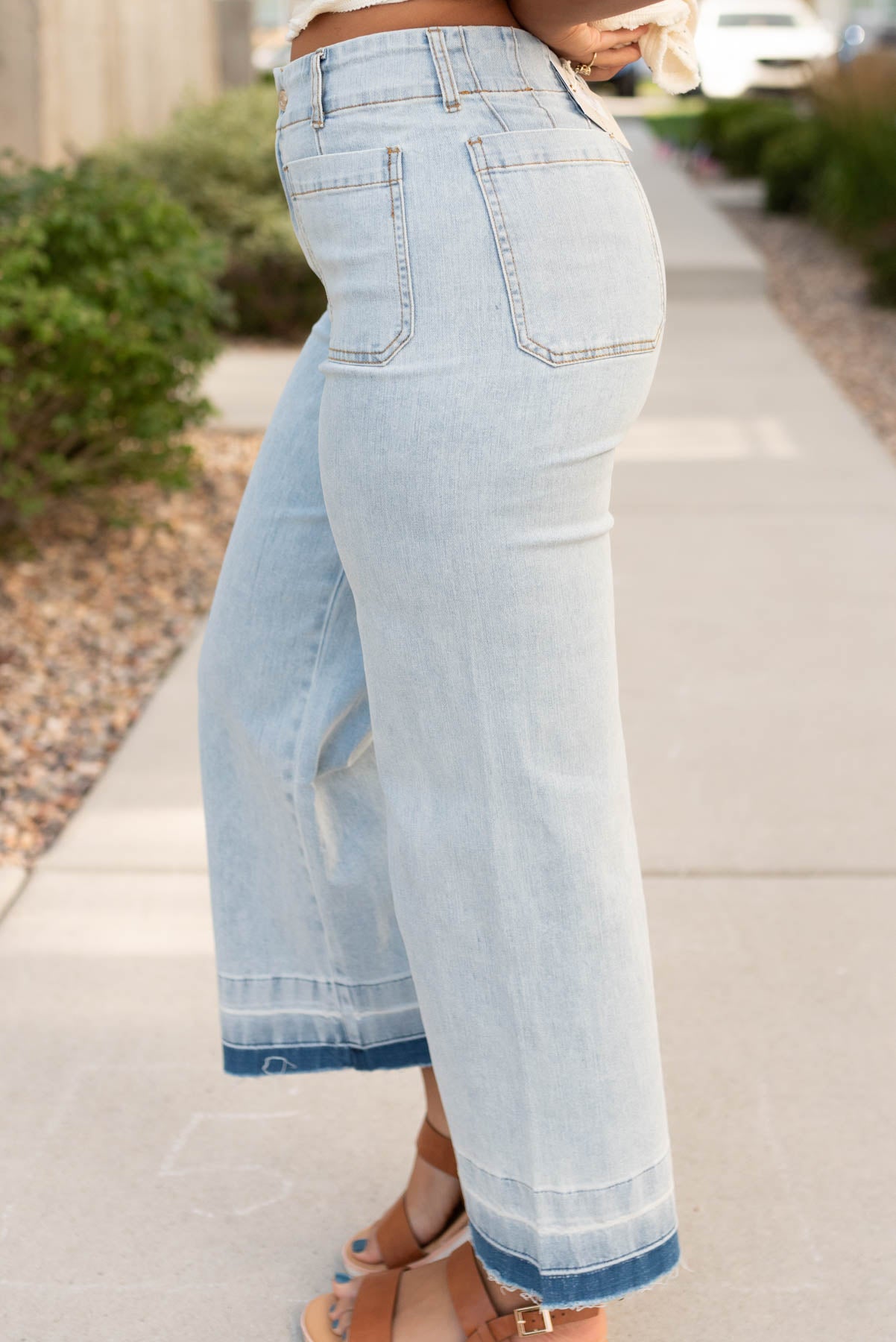 Side view of the light dneim raw hem pants