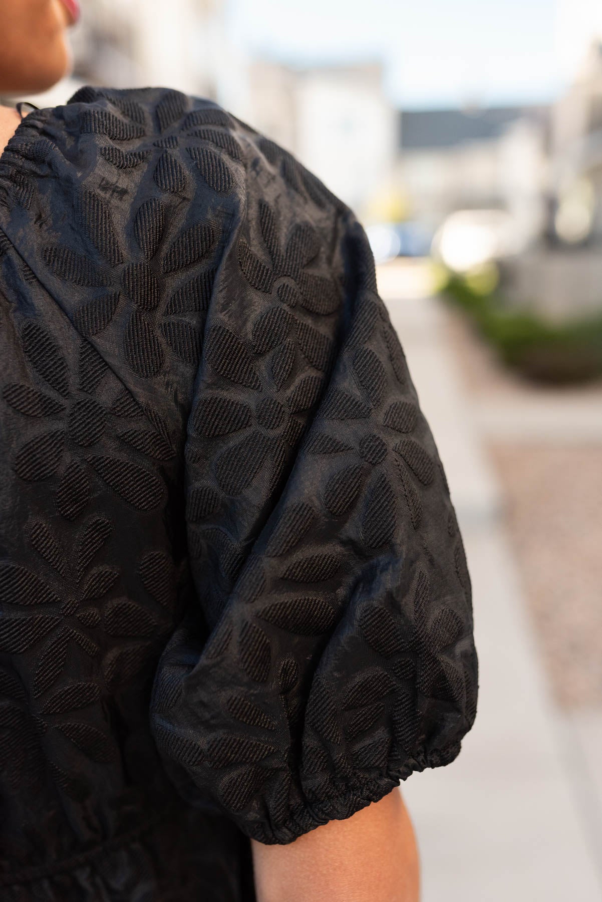 Close up of the sleeve and fabric on the black tiered floral dress