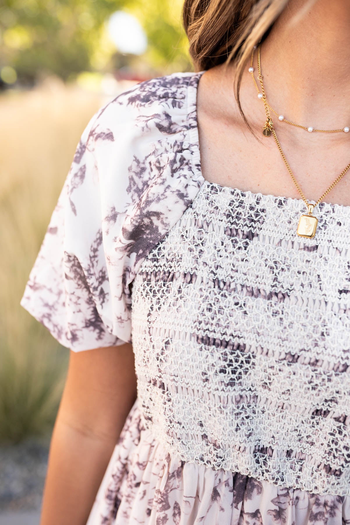 Close up of the fabric and smocking on the cream floral smocked dress