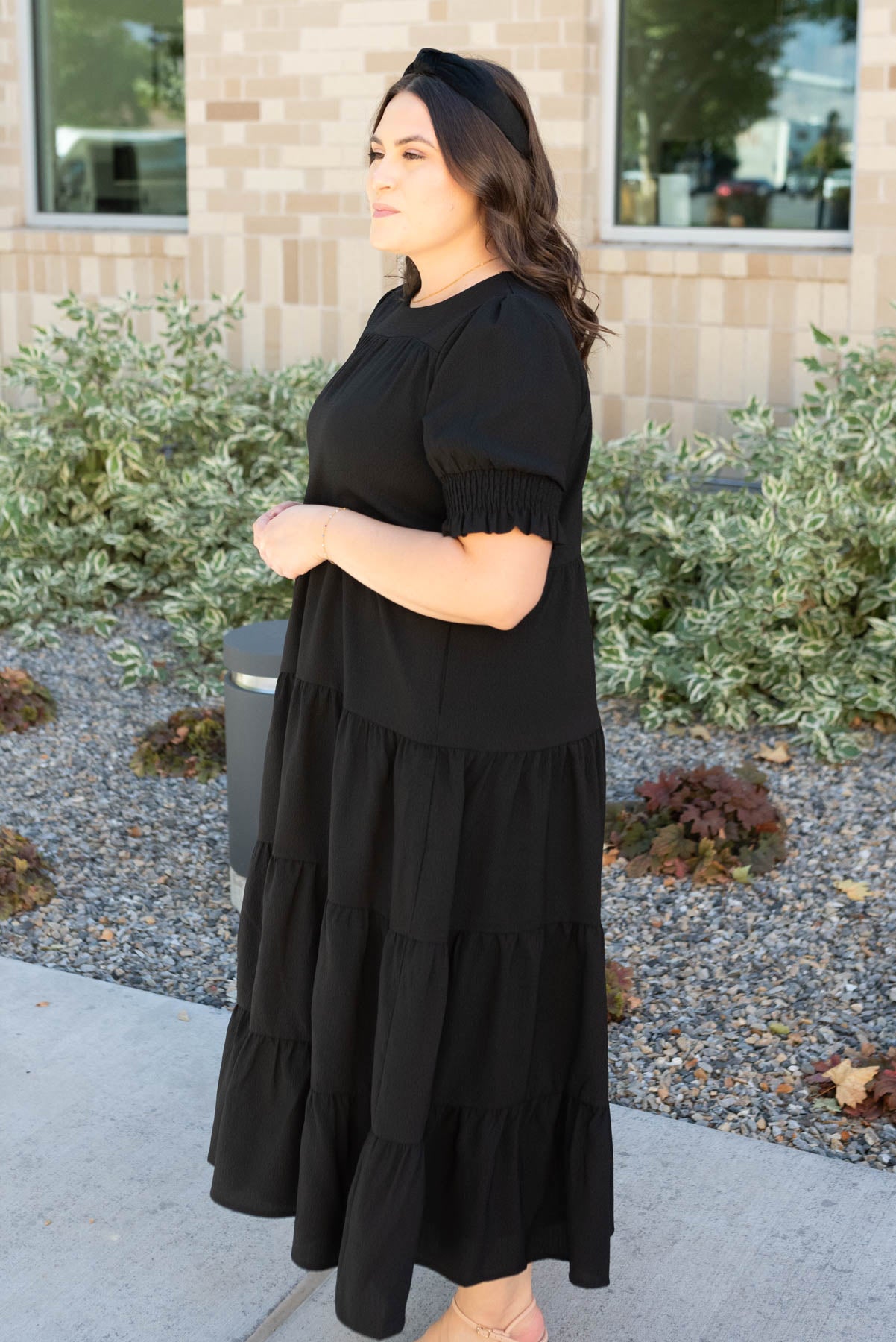 Side view of the plus size tiered black dress