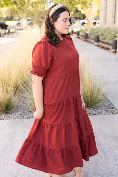 Side view of the tiered rust dress in plus size