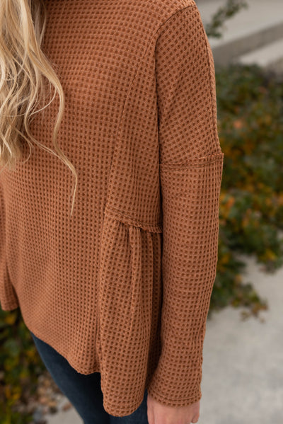 Close up of the fabric on a brown top