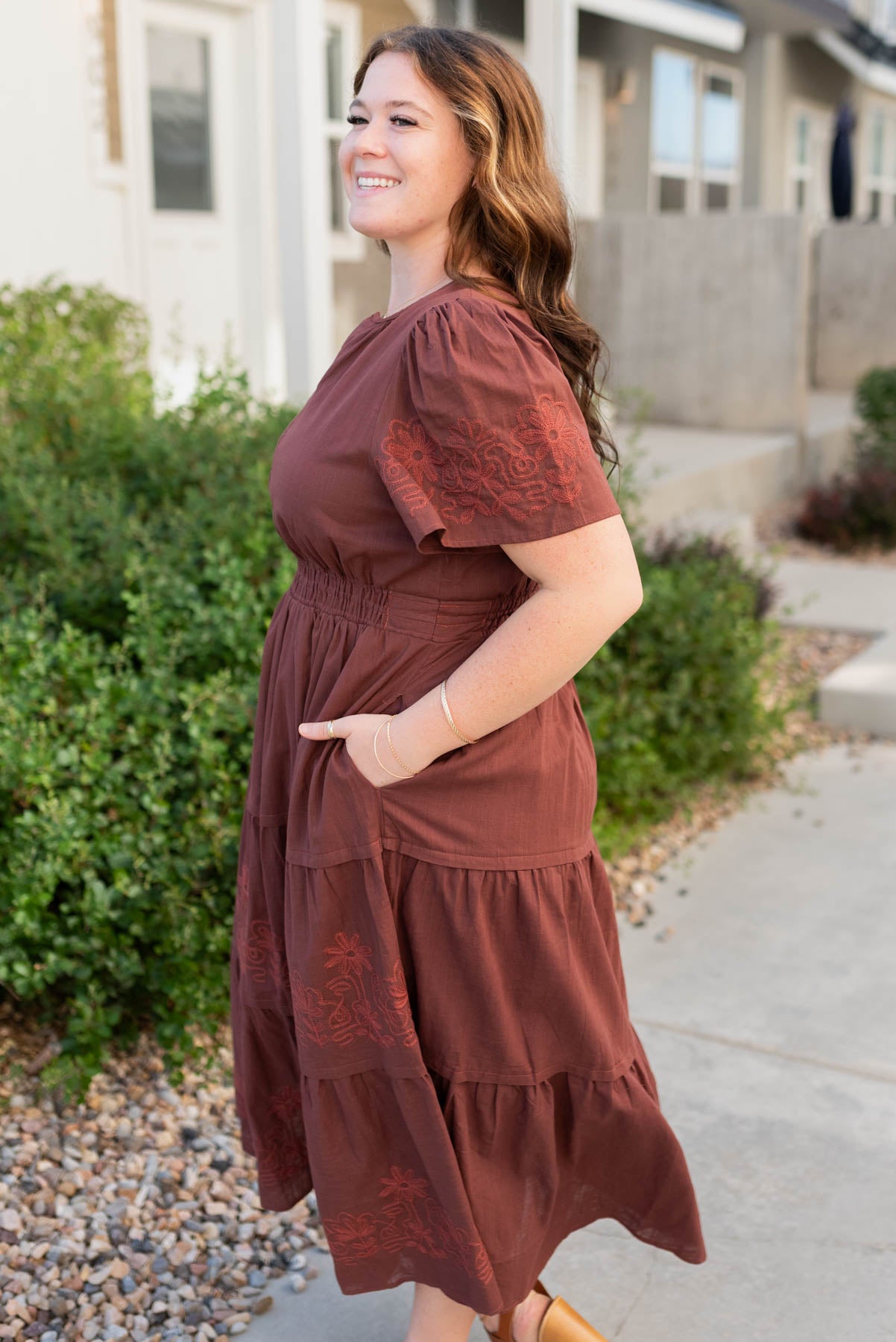 Side view of the burgundy embroidered detail dress in plus size with pockets