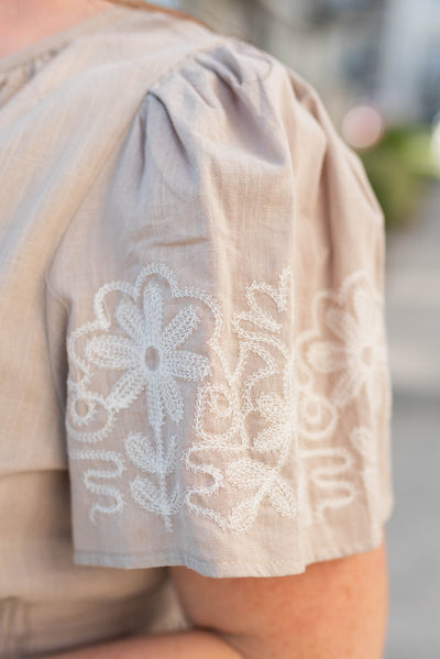 Close up of the embroidery on the sleeve of the plus size taupe embroidered detail dress