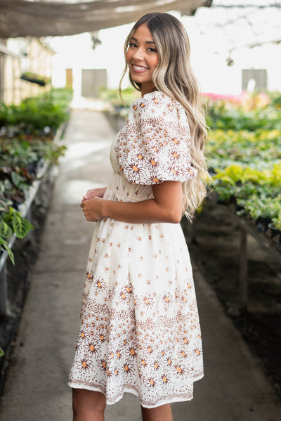 Side view of the beige daisy dress with a puff sleeve