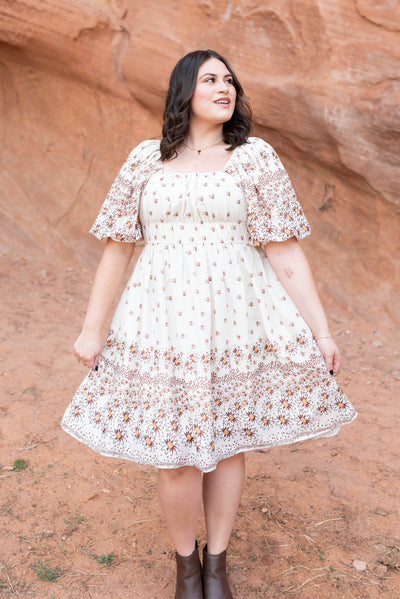 Plus size beige daisy dress that is knee length with a square neck