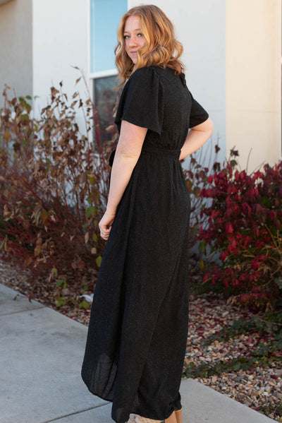 Side view of a black sparkle maxi wrap dress