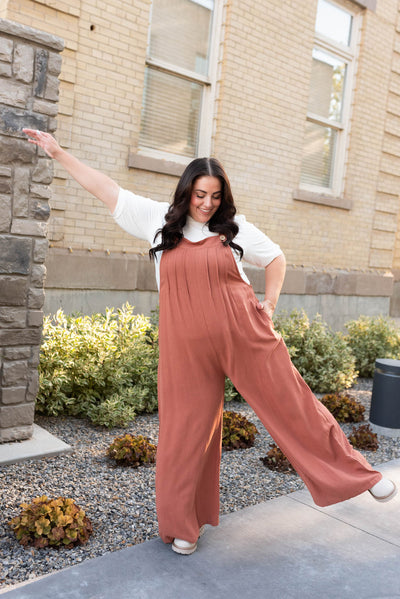 Button straps on the rust wide leg overalls in plus size