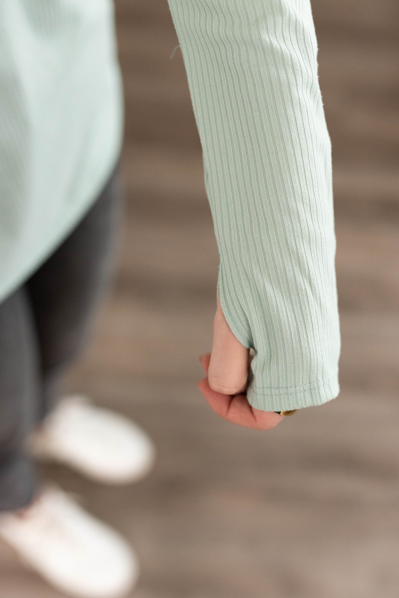 Close up of the sleeve on the sage ribbed long sleeve top