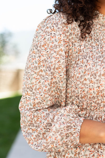 Close up of the sleeve on the beige floral smocked dress