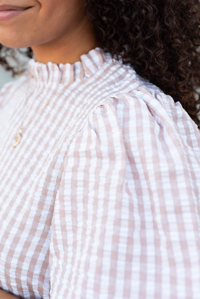 Close up of the fabric and ruffle at the neck on the latte gingham puff sleeve tope