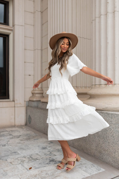 White tiered textured dress with short sleeve and ruffle around the cuff