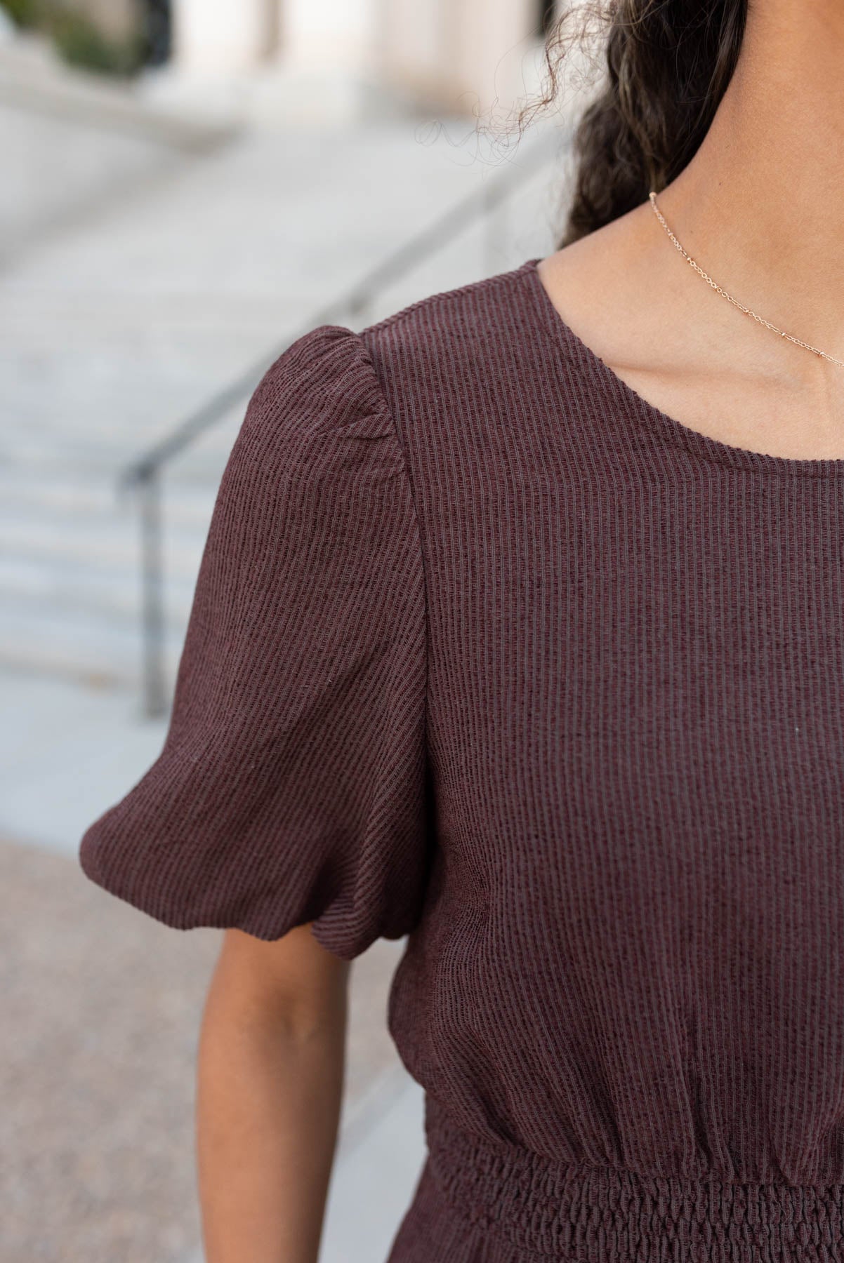 Close up of the sleeve and fabric on the brown textured dress