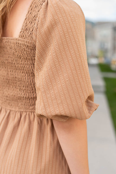 Close up of the sleeve of the taupe square neck dress