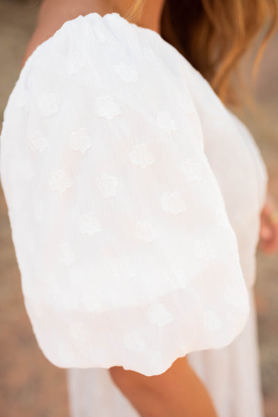 Close up of the puff sleeve on the white flroal sqaure neck dress