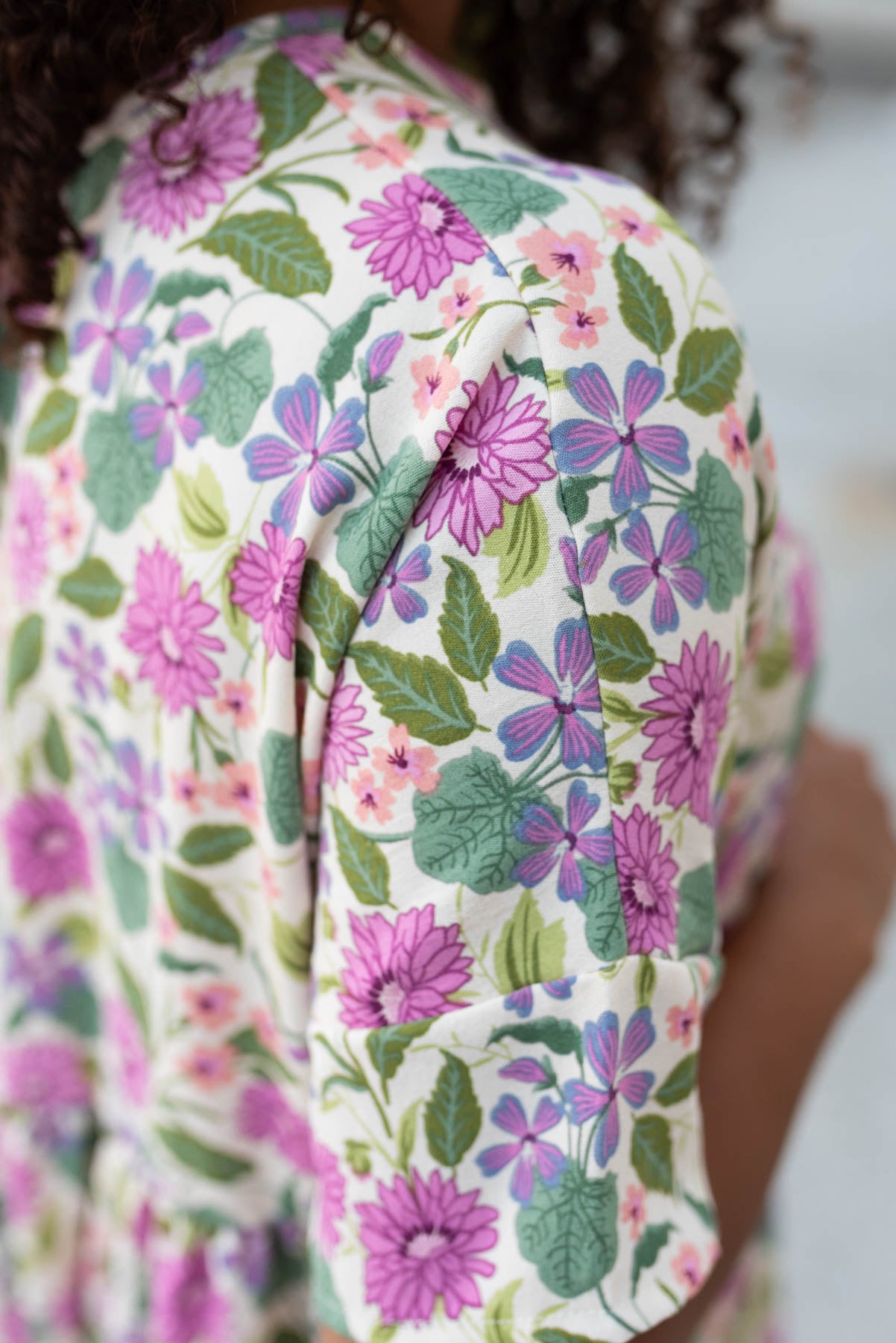 Close up of the fabric and sleeve on the ivory multi floral dress