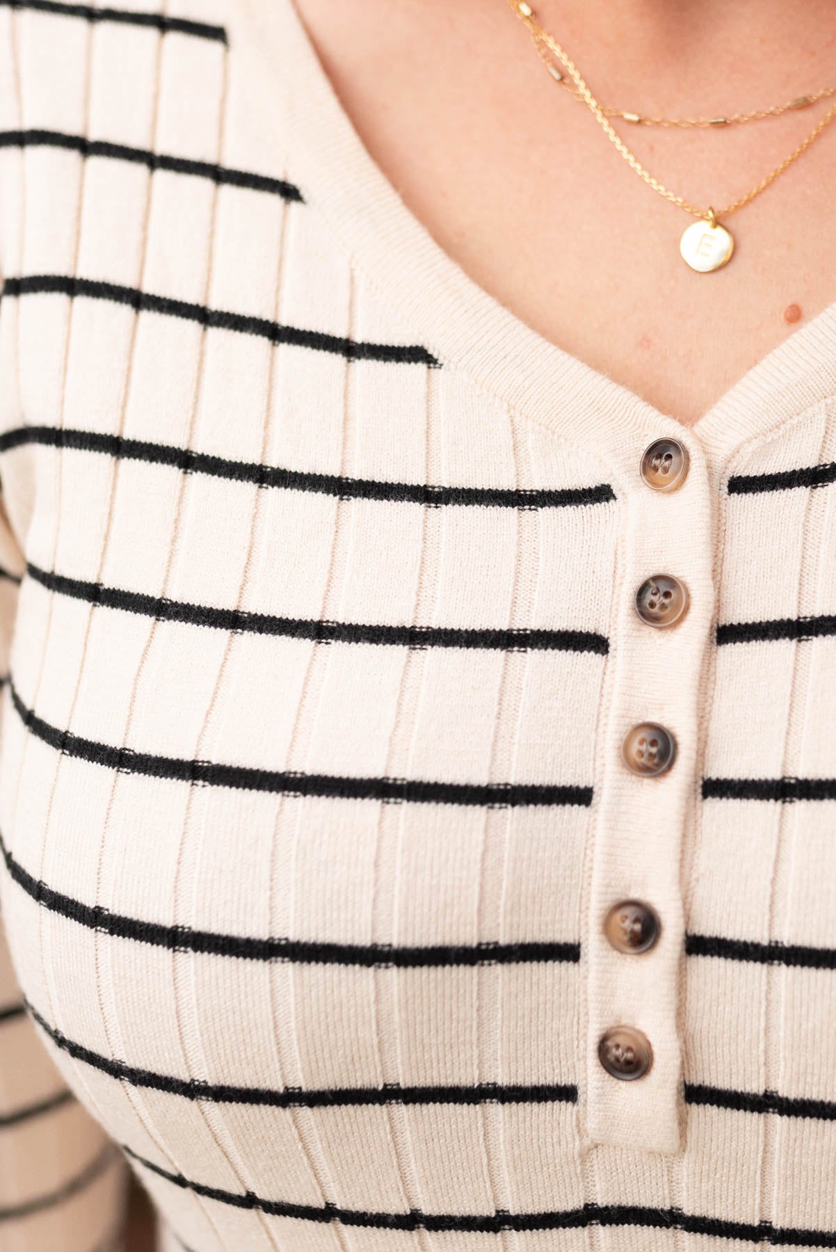 Close up of the fabric and button on the oatmeal stripe sweater dress