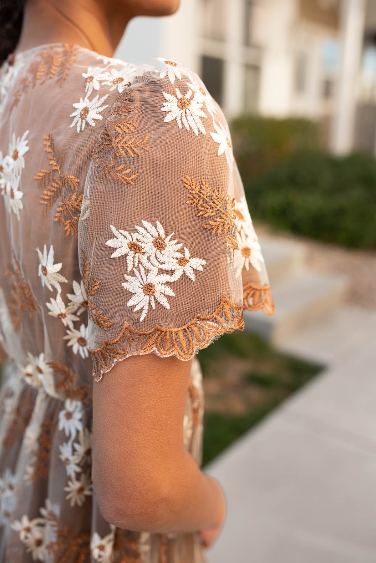 Close up of the fabric and sleeve on the brown embroidered dress