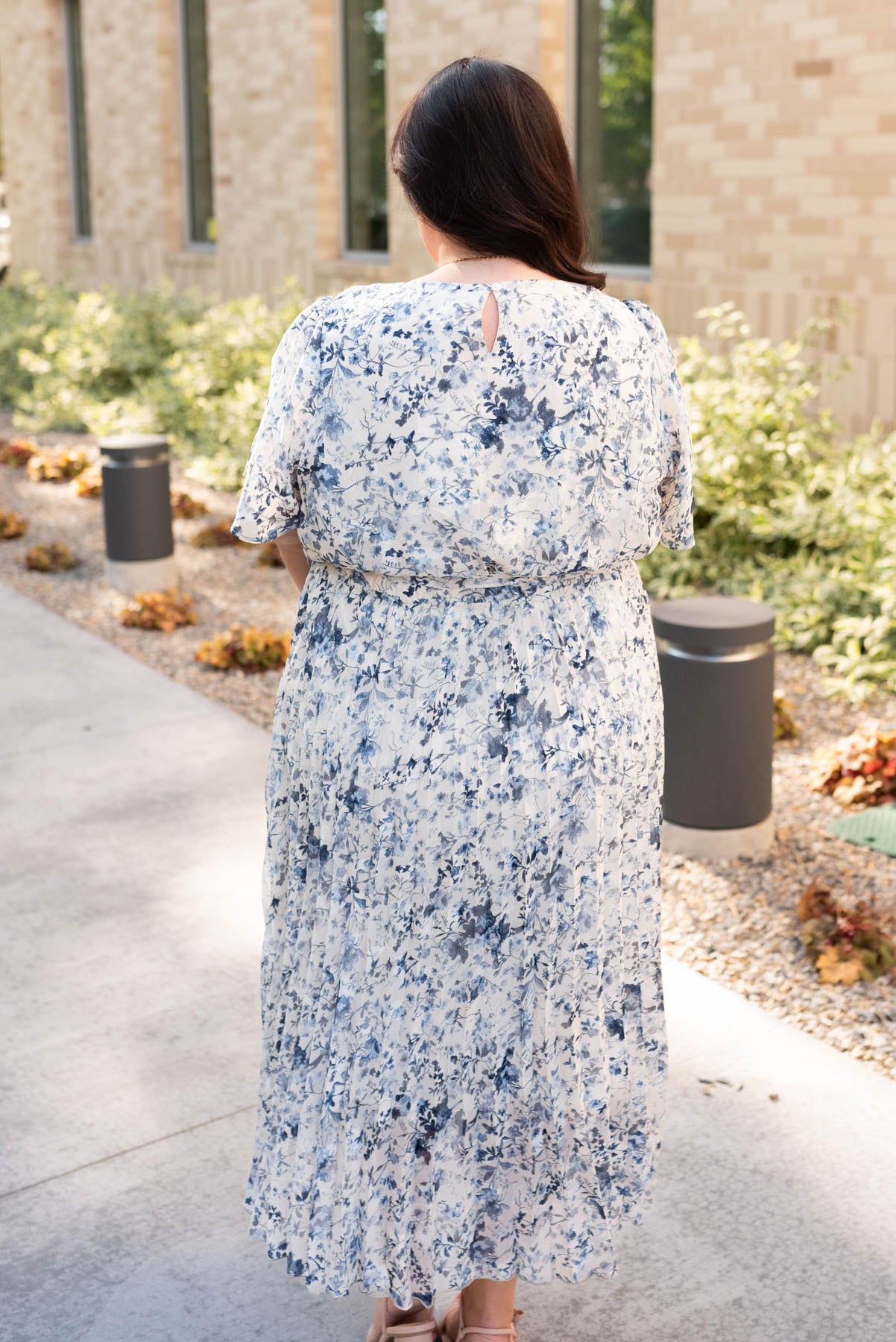 Back view of the plus size blue floral pleated dress