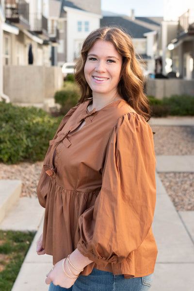 Side view of the plus size toffee bow top