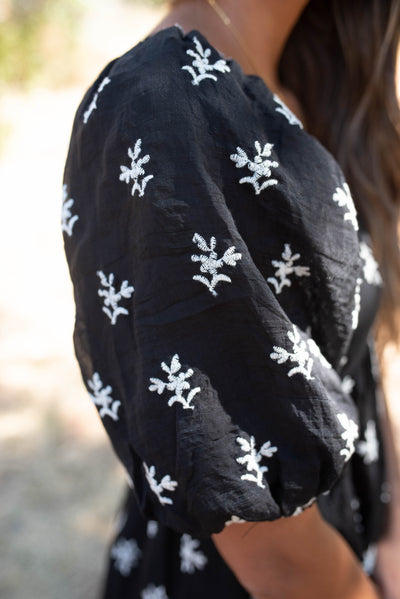 Close up of the sleeve and fabric of the black floral tiered dress