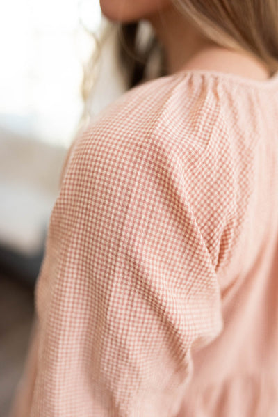 Close up of the sleeve and fabric of a blush tiered dress