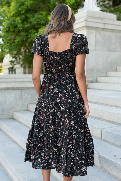 Back view of the black floral tiered dress with square neckline