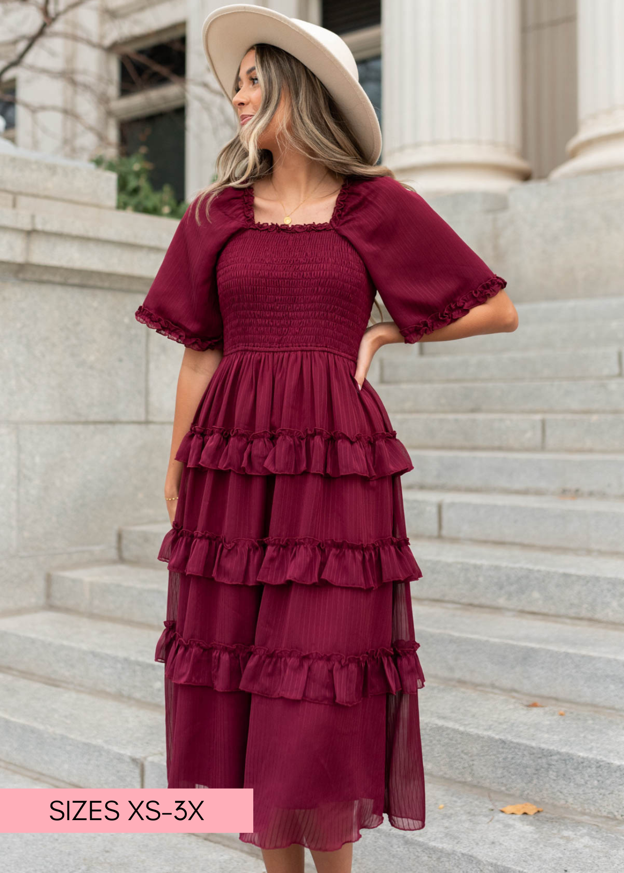 Front view of a burgundy tiered dress with square neck