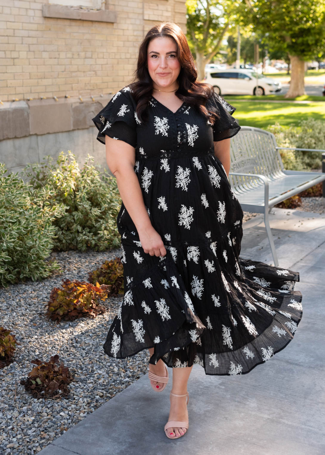 Front view of the plus size black embroidered tiered dress