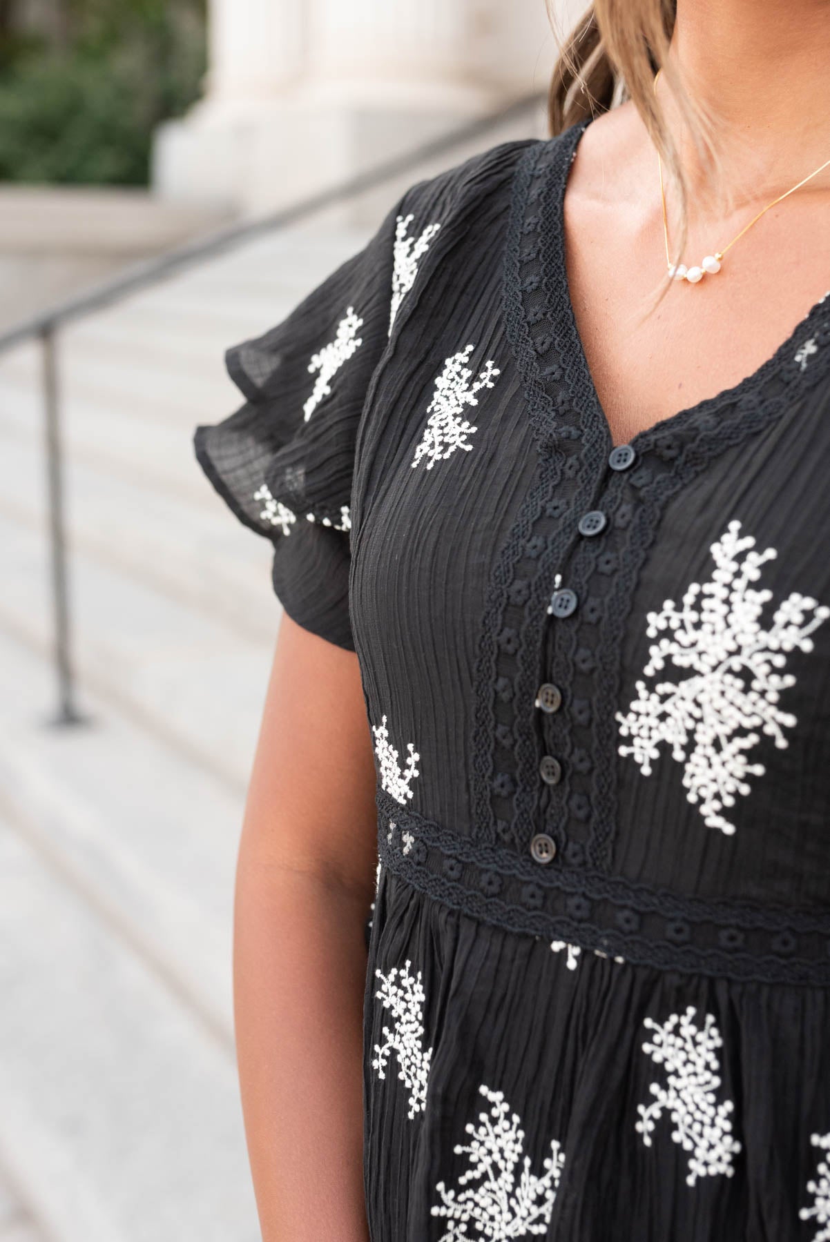 Close up of the buttons on the bodice of the black embroidered tiered dress